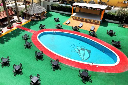 an overhead view of a swimming pool with tables and chairs at Delmon International Hotel in Manama