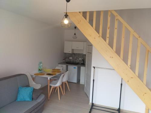 a living room with a staircase and a kitchen with a table at Apartamenty Pasternik 7 SUCHEDNIÓW in Suchedniów