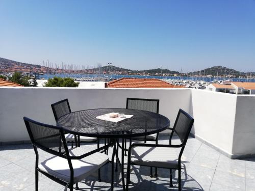 a black table and chairs on a balcony with a view at Apartman Dino in Murter