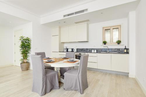 a white kitchen with a table and chairs at Apartment G621 - Lustica Bay in Tivat