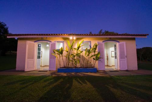 a house with purple doors and a plant in front at Hotel Alto da Boa Vista in Analândia