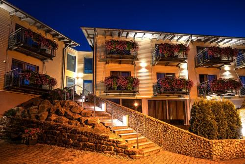 a building with flower boxes and stairs in front of it at Hotel Waldblick in Schenkenzell
