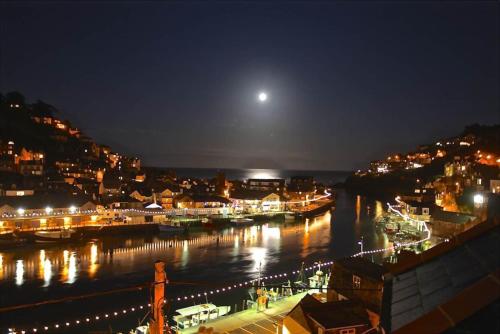 a view of a harbor at night with a full moon at Polmear Harbour View With Terrace in Looe