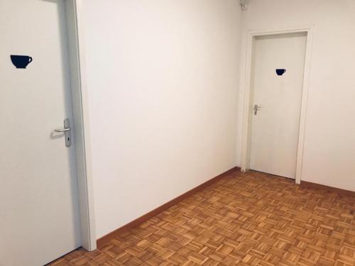 an empty room with two doors and a wooden floor at Lugano 33A - No Bikes - Self check-in in Lugano