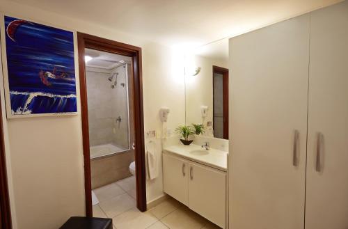 a bathroom with a sink and a bath tub at Elegance Comfort Natal Beira mar Coberturas Vip in Natal