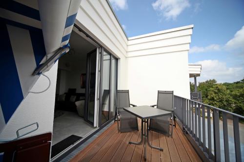 a balcony with a table and chairs on a deck at Villa Düne -Penthousewohnung WE 18 in Baabe