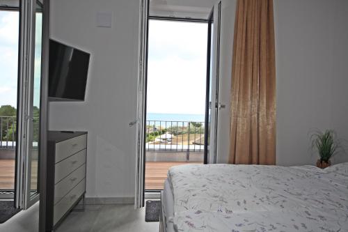 a bedroom with a bed and a television and a balcony at Villa Düne -Penthousewohnung WE 18 in Baabe