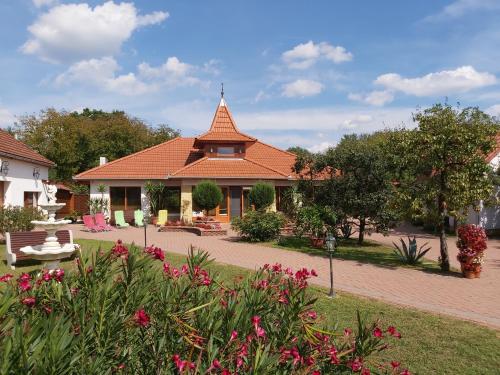 Tiszabecs的住宿－Bornemisza Kuria，一座红色屋顶的房子和一个鲜花盛开的花园