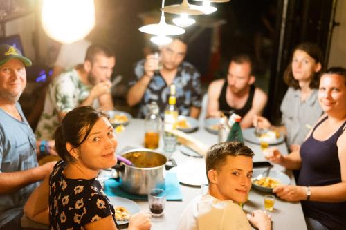 a group of people sitting around a table eating food at Good People Design Hostel in Belgrade