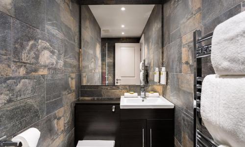 a bathroom with a sink and a mirror at Kotel Windermere in Windermere