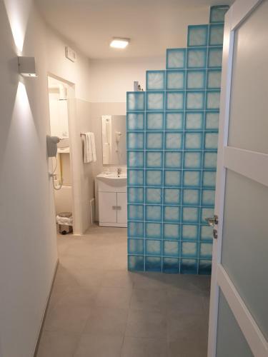 a bathroom with a blue glass door and a sink at Hotel Raibl e Appartamenti in Tarvisio