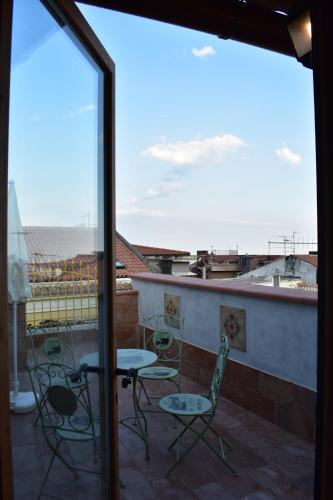 a patio with chairs and a table on a balcony at Sicilia In Miniatura "L'Atelier dell'Etna" in Zafferana Etnea