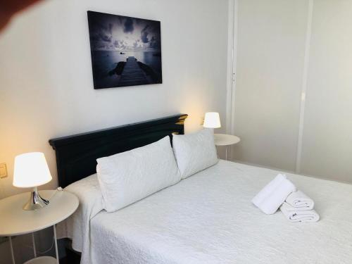 コラレホにあるApartamento Centrico Corrralejoのベッドルーム1室(白いベッド1台、テーブル2台、ランプ2つ付)