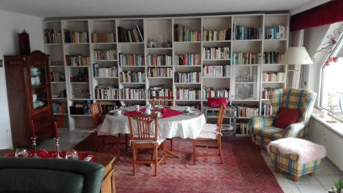 a dining room with a table and bookshelves filled with books at Ferienwohnung Kück-Rathausstrasse in Hahnenklee-Bockswiese