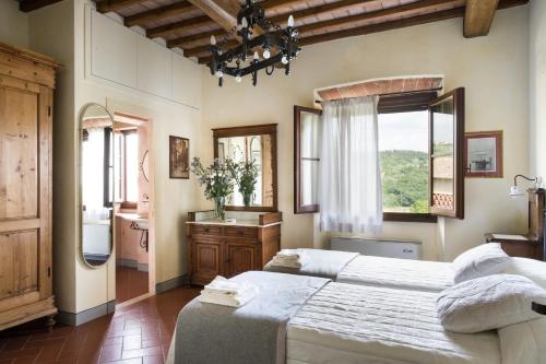 a bedroom with a large white bed and a sink at Fattoria Pogni in Marcialla
