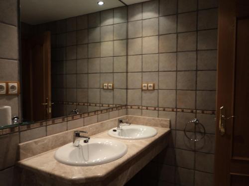 a bathroom with two sinks and a large mirror at Apartamentos Solans in Bielsa