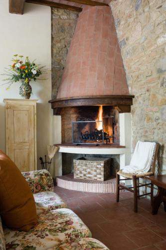 a brick fireplace in a living room with a couch at Fattoria Pogni in Marcialla