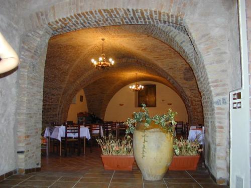 un ristorante con un grande vaso con piante di Antico Frantoio a Cerchiara di Calabria