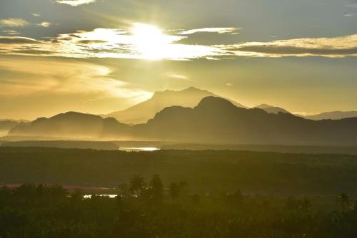 a sunset over a mountain range with the sun in the sky at Ao Luek Panoramic Pool-SHA Plus in Ao Luk