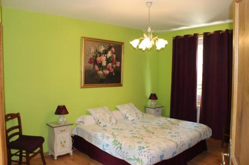 a bedroom with a bed and a painting on the wall at Moulin de Bray - Chambres d'hotes et hébergement Insolite in Vieux-Vy-sur-Couesnon