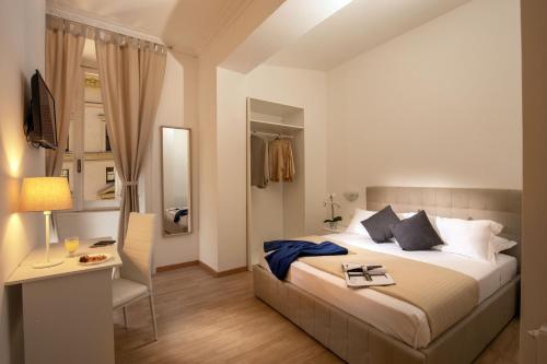 a hotel room with a bed and a desk and a bedroom at Domus Veneto Rome in Rome