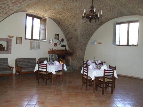 a dining room with two tables and chairs and a chandelier at Antico Frantoio in Cerchiara di Calabria