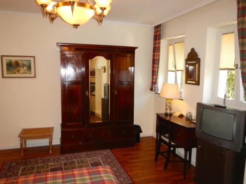 a living room with a dresser and a television at Hotel Villa Meererbusch in Meerbusch