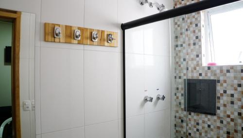 y baño con ducha y puerta de cristal. en Hotel Casa Ocarina, en São Paulo