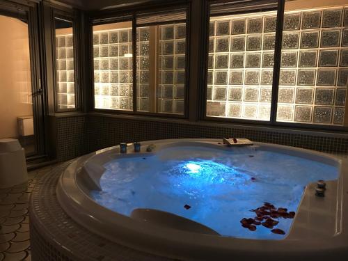 a large bath tub with blue water in a bathroom at WATER HOTEL Cy (Audlt Only) in Machida