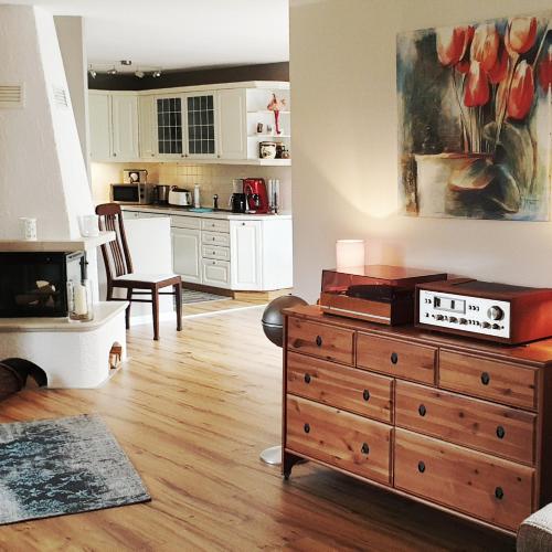a living room with a dresser and a kitchen at Haus Tina in Mölln