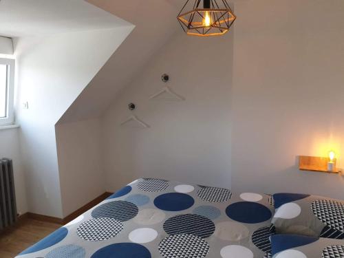 a bedroom with a bed with a blue and white comforter at Le bélouga in Sangatte