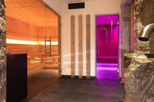 ein Bad mit einer lila Tür in einem Zimmer in der Unterkunft Hotel Olympia in Sarntal