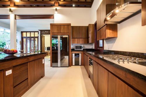 a large kitchen with wooden cabinets and counters at Baan Pinya Balinese Style Pool Villa in Krabi town