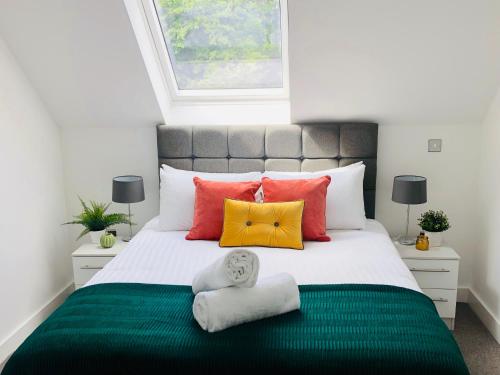 a bedroom with a large bed with colorful pillows at Shield Penthouse Loft - 2 Bedroom Luxe Large Apartment in Sheffield