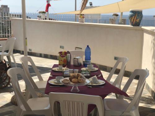 a table with a plate of food on a balcony at La Ruota B&B in Terrasini