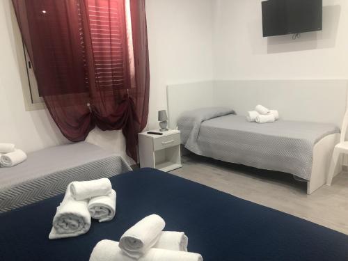 a small room with two beds and towels at La Ruota B&B in Terrasini