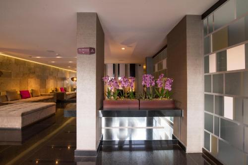 a lobby with purple flowers in a pot on a shelf at Arawi Miraflores Prime in Lima