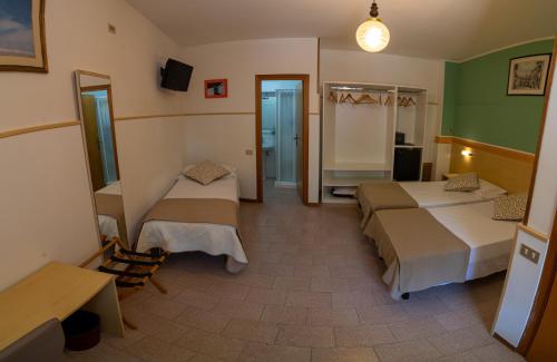 a hotel room with two beds and a bathroom at Due Torri in San Severino Marche
