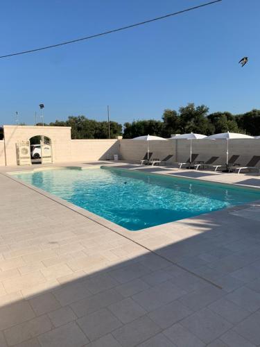 a swimming pool with chairs and blue water at Le Terrazze Miramare B&B in Torre Canne