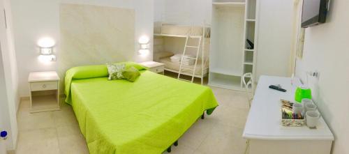 a bedroom with a green bed and a white table at Le stanze di chiara in Torre Lapillo