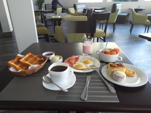 a table with a breakfast of eggs toast and coffee at Hotel Calacoto in La Paz