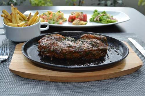 a plate of meat and french fries on a table at Hotel Calacoto in La Paz