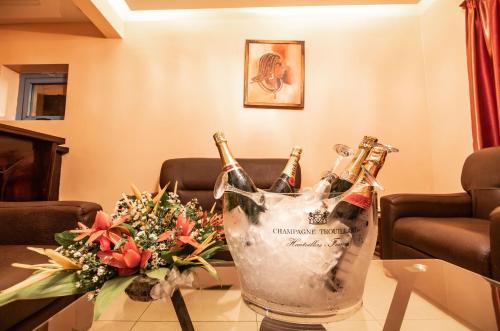 洛美Bravia Eco Hotel Lome的桌上摆着两瓶香槟和鲜花