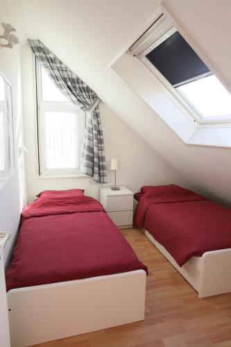 two beds in a bedroom with a roof at Vakantievilla Markant in Balk