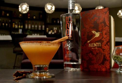 a drink sitting on a table next to a bottle of kennisin at Hotel Calacoto in La Paz