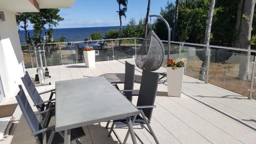 a table and chairs on a balcony with the ocean at Z widokiem na morze in Rewal