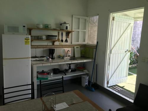 uma cozinha com um frigorífico branco e uma mesa em green house two bedrooms em Sámara