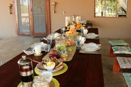 a table with plates of food on top of it at Ngalali Retreat in Grietjie Nature Reserve
