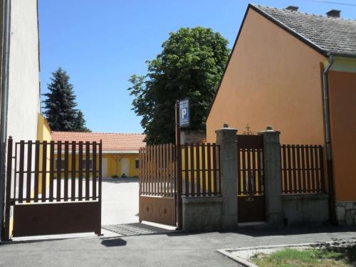 a gate in front of a building with a house at Belvárosi Rezidencia Pápa in Pápa