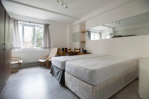 a bedroom with a large bed and a mirror at Central London Maida Vale 4 or 5 bed spacious apartment in London